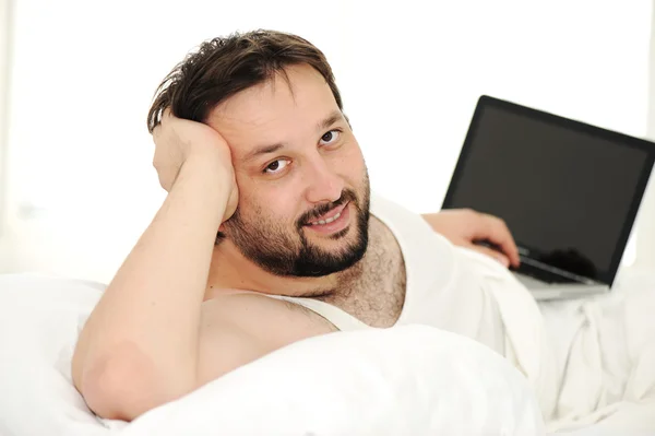 Άνθρωπος στον ύπνο κρεβάτι χρησιμοποιώντας φορητό υπολογιστή — Φωτογραφία Αρχείου
