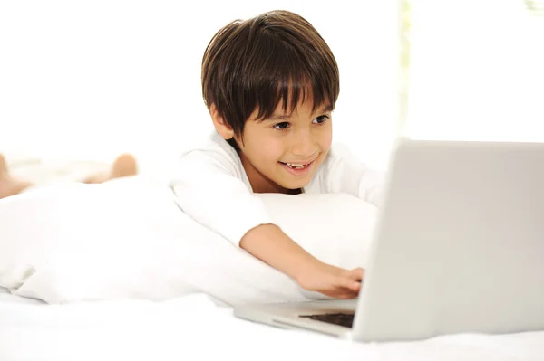 Niño con portátil en la cama, tiempo feliz — Foto de Stock