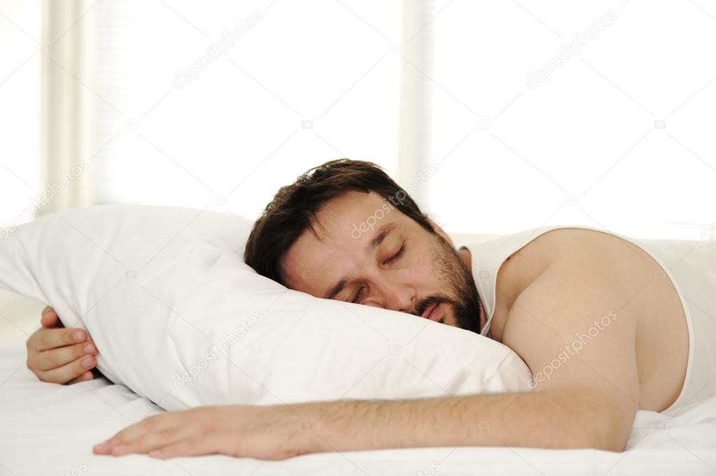 Man in sleeping bed, morning time