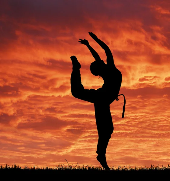 Desporto acrobático menina contra fantástico céu vermelho — Fotografia de Stock