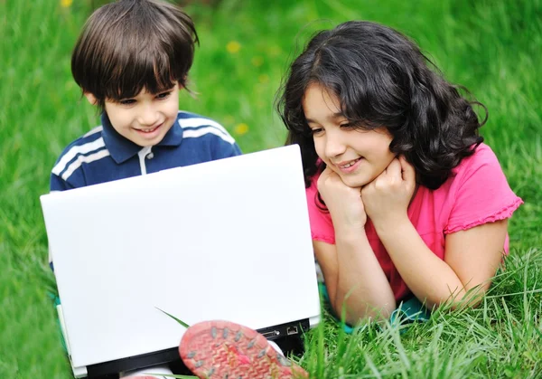 Atividades de crianças com laptop na natureza — Fotografia de Stock