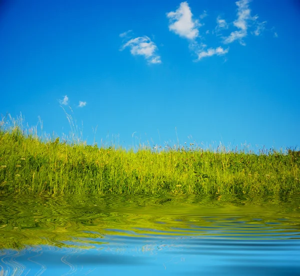 Een afbeelding van blauwe lucht en groen veld — Stockfoto