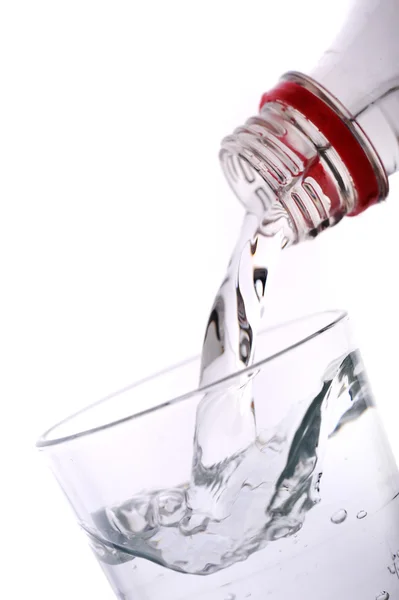 Bottiglia versando acqua in un bicchiere blu — Foto Stock