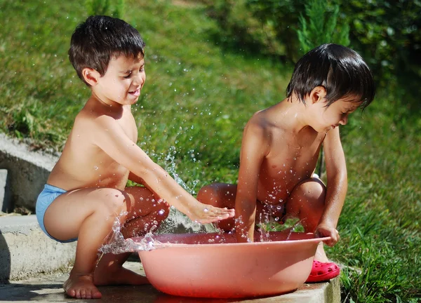 Sehr nettes Kind spielt mit Wasser im Freien — Stockfoto