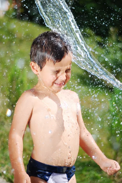 Bambino molto carino che gioca con l'acqua all'aperto — Foto Stock