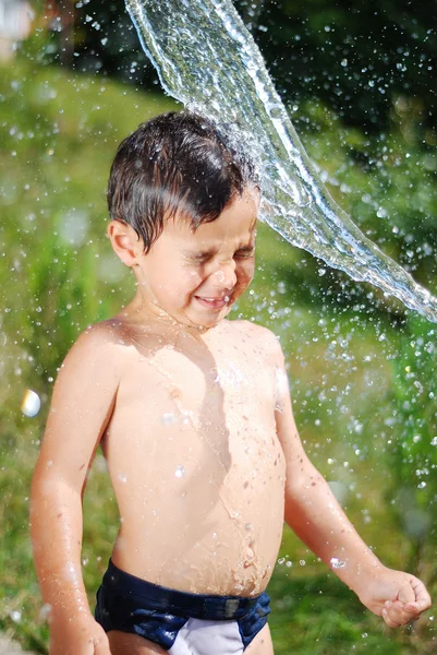 Sehr nettes Kind spielt mit Wasser im Freien — Stockfoto