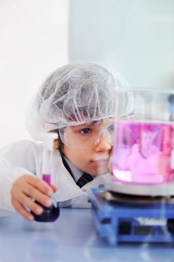 Akıllı şirin küçük erkek çocuk çok modern hastane laboratuarında test tüpleri ile deneyler