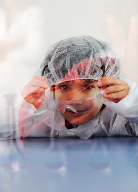 Akıllı şirin küçük erkek çocuk çok modern hastane laboratuarında test tüpleri ile deneyler