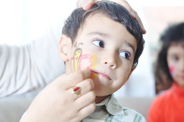 Criança positiva com cores no rosto e no corpo — Fotografia de Stock