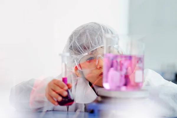 Inteligente bonito pequeno macho criança experimentando com tubos de ensaio no real moderno laboratório hospitalar — Fotografia de Stock