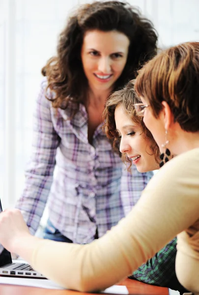 Gruppe junger Glücklicher schaut in Laptop, der daran arbeitet — Stockfoto