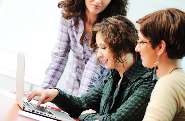 Gruppe junger Glücklicher schaut in Laptop, der daran arbeitet — Stockfoto