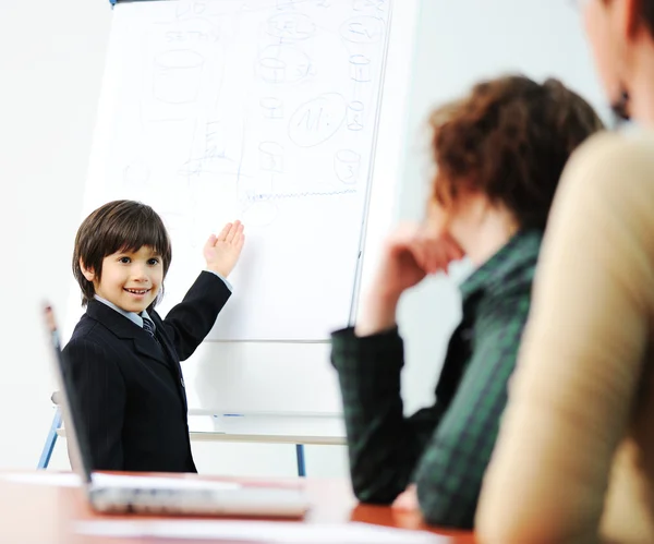 Геніальна дитина на бізнес-презентації розмовляє з дорослими і читає їм лекцію — стокове фото