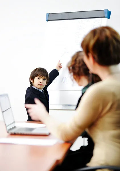 Niño genio en presentación de negocios hablando con adultos y dándoles una conferencia — Foto de Stock