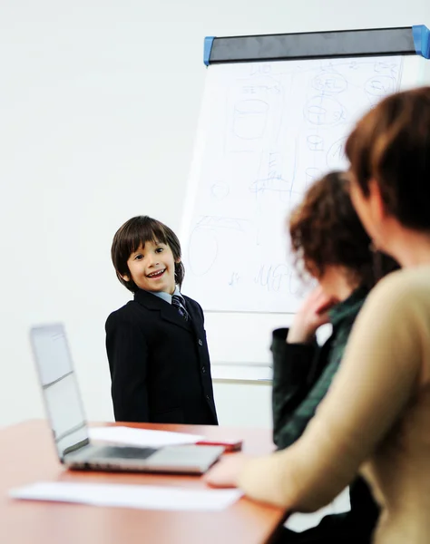 Niño genio en presentación de negocios hablando con adultos y dándoles una conferencia — Foto de Stock