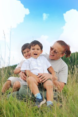 Büyükannen ile doğadaki mutlu üç çocuk