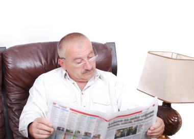 Orta yaşlı adam oturmuş ve Gazeteler okuma