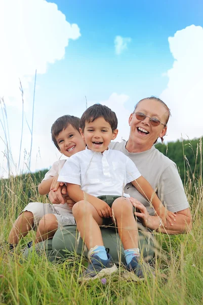 Glad tre barn i naturen med mormor — Stockfoto