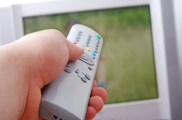 Telecomando in mano diretto verso la televisione — Foto Stock