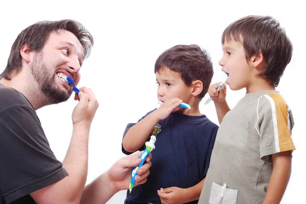 Młody człowiek uczy dzieci, jak do czyszczenia zębów — Zdjęcie stockowe