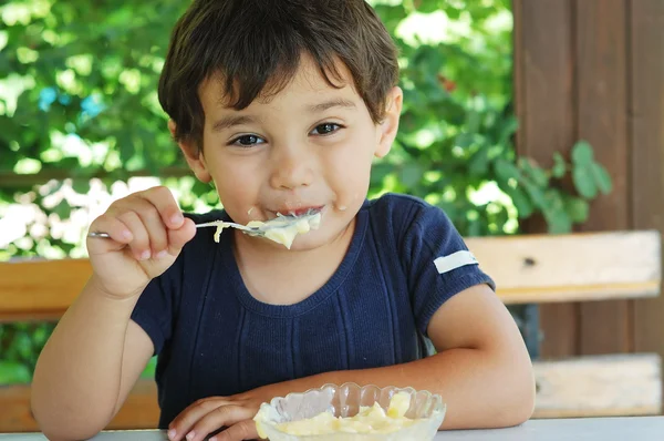 Lindo niño comiendo helado y disfrutando — Foto de Stock