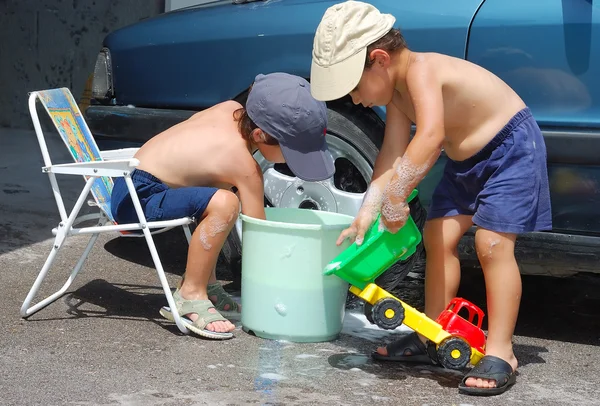 子供車、おもちゃの車を洗う — ストック写真