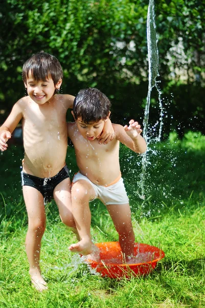 Two kids summer playing with water outdoor — Stock Photo, Image