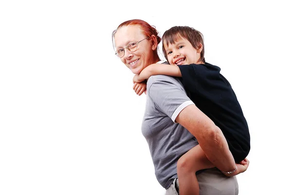 Middle aged woman holding little boy on her back — Stock Photo, Image
