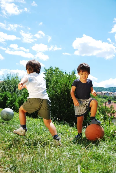 Duas crianças com basquete e futebol Imagens De Bancos De Imagens