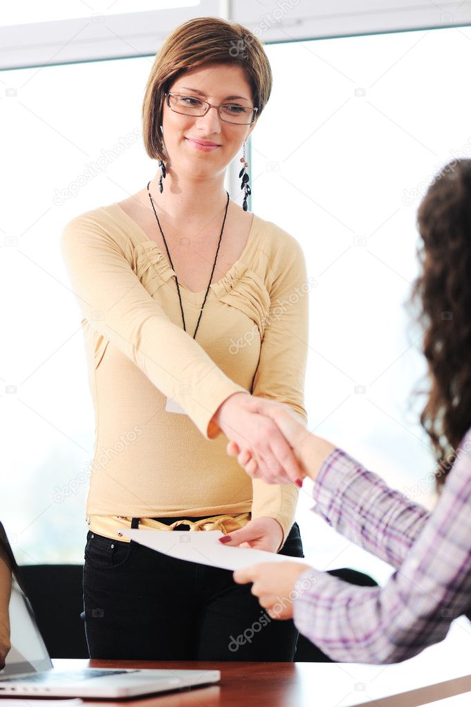 Closing a deal with a handshake. Signed contract in the hand between women.