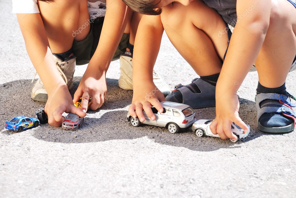 Toys cars in front of children legs