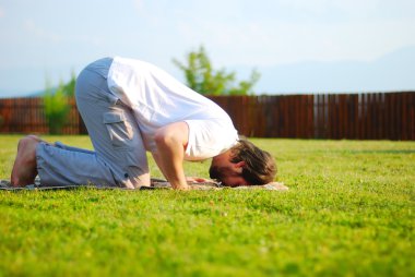 yeşil çayır dua üzerinde çekici genç adam