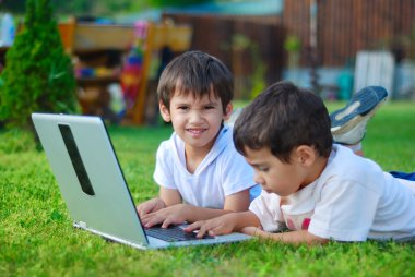 iki sevimli çocuk laptop çim döşeme