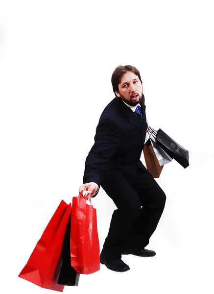 Joven atractivo hombre usando traje y sosteniendo bolsas de compras —  Fotos de Stock