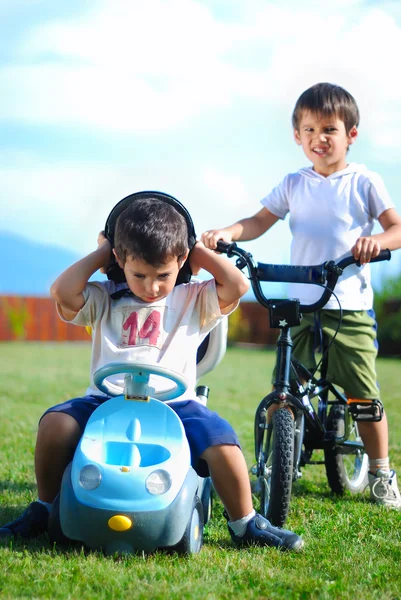 Actividad infantil con camión de juguete y bicicleta en prado verde —  Fotos de Stock