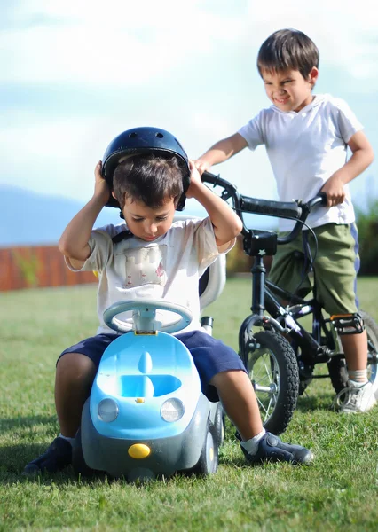 Jeugd activiteit met vrachtwagen speelgoed en fiets op groene weide — Stockfoto
