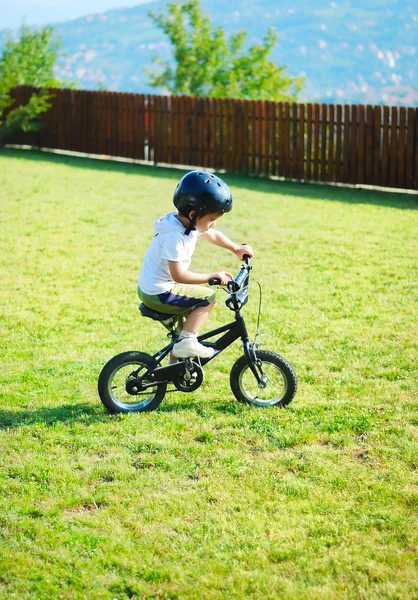 Childhood activity with bike on green meadow — Stock Photo, Image