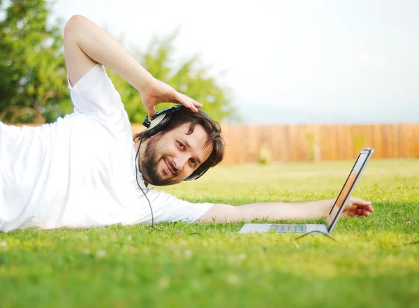 Young attractive man on green meadow — Stock Photo, Image