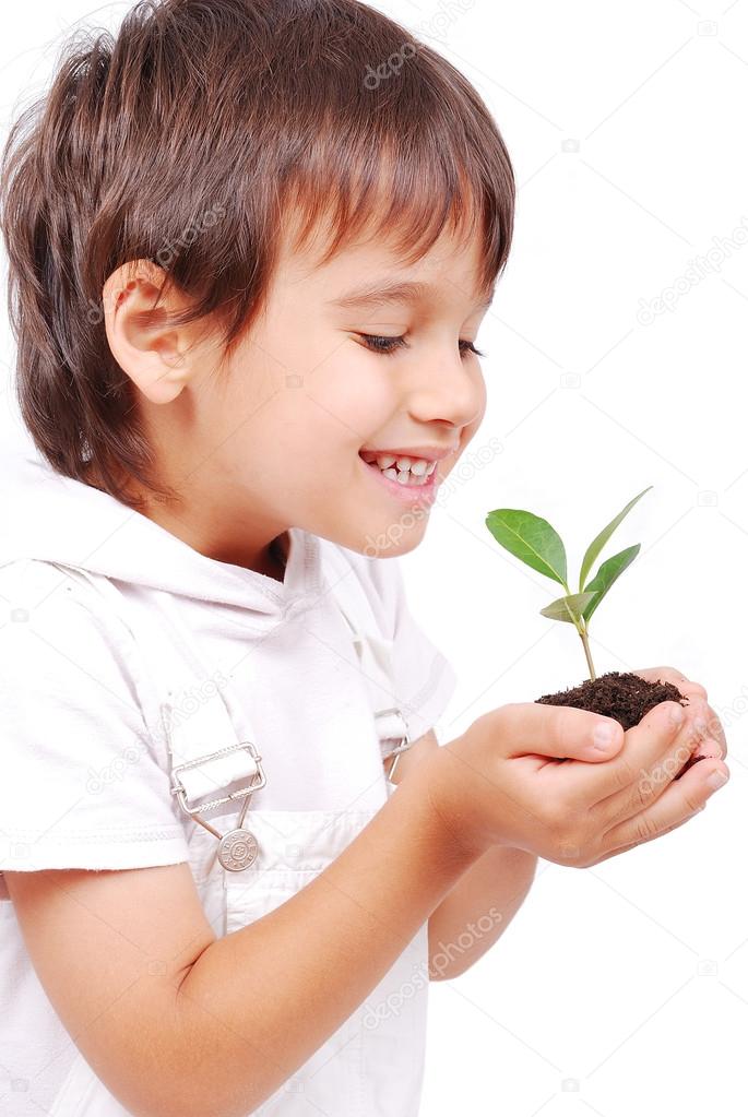 Little cute child holding green plant in hands
