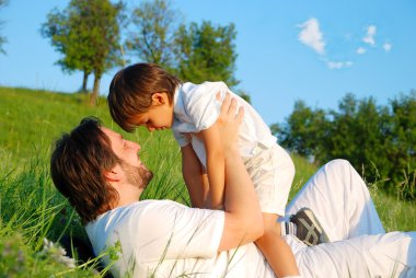 Beyaz çocuk üzerinde güzel çayır ile genç Baba