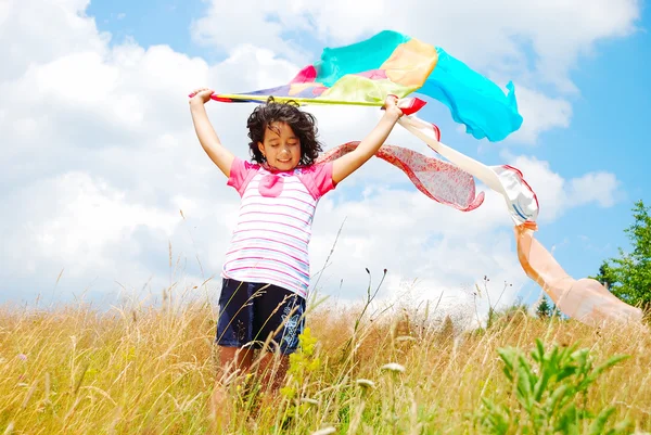 A little pretty girl with scarf above head on medow — Stock Photo, Image