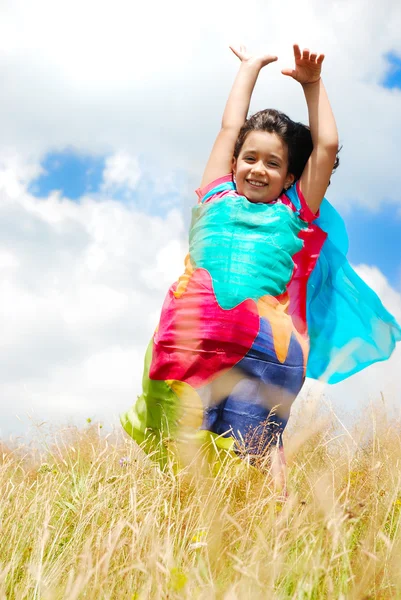 Uma menina bonita com cachecol acima da cabeça no medow — Fotografia de Stock