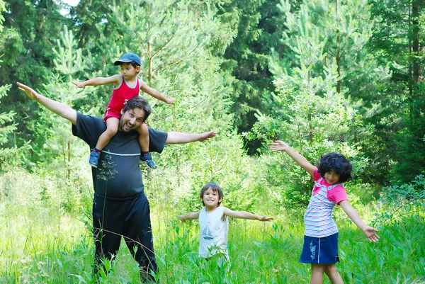 Pai feliz e três filhos na natureza — Fotografia de Stock