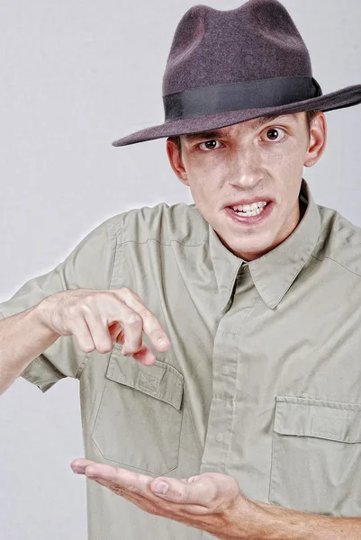 Mladí hříva s kloboukem ukazuje prstem — Stock fotografie
