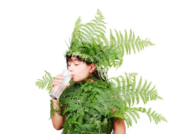 Досить маленька дівчинка, одягнена в зелене листя рослин — стокове фото