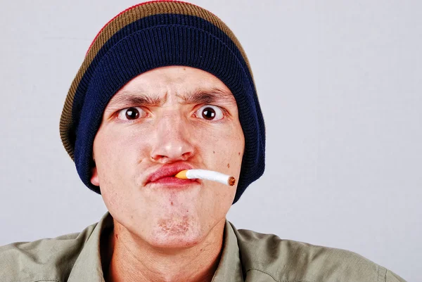 Roliga ansikte ung man med cigarete i hand — Stockfoto
