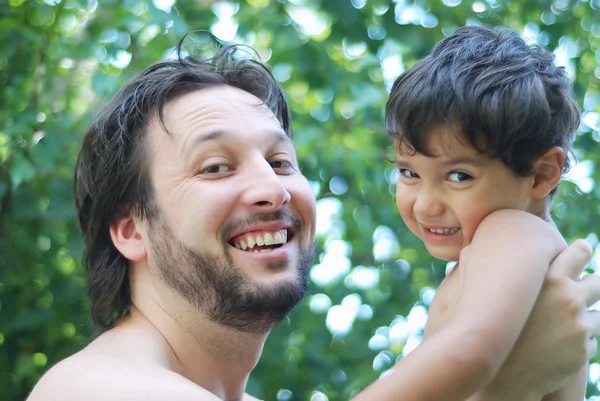 Lovely boy and his father holding him in hands in nature — Stock Photo, Image