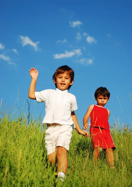 Feliz infancia inolvidable en el prado verde contra el cielo azul — Foto de Stock