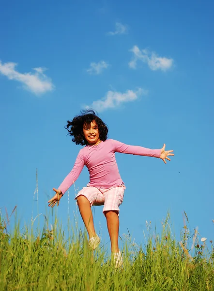 Šťastné nezapomenutelné dětství na zelené louce proti modré obloze — Stock fotografie