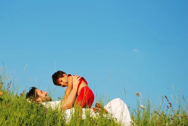 Jeune père en blanc avec enfant sur une belle prairie — Photo